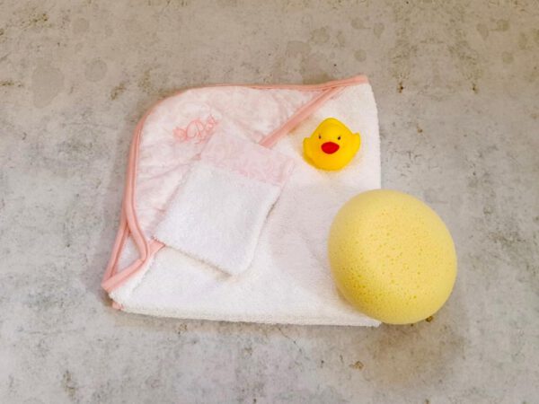 Capa de baño toalla blanca con estampado cachemir rosa, manopla y esponja.
